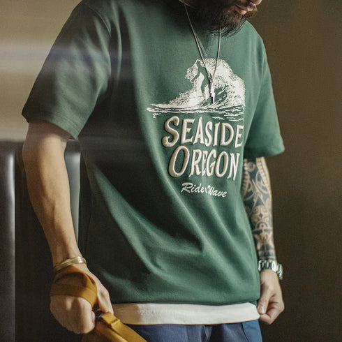 Person wearing a green t-shirt with 'Seaside Oregon' design